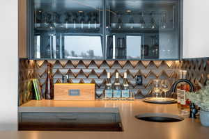 Bar featuring backsplash and sink