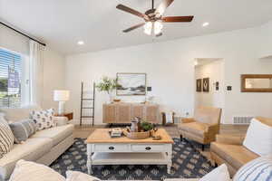 Living room featuring ceiling fan, lofted ceiling, and hardwood / wood-style flooring