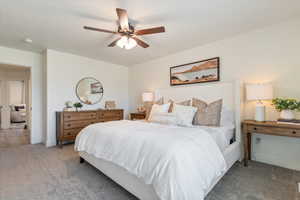 Carpeted bedroom featuring ceiling fan