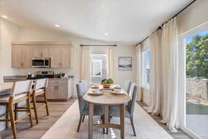 Dining space featuring light hardwood / wood-style flooring and vaulted ceiling