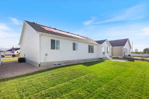 Back of property featuring a yard and central AC