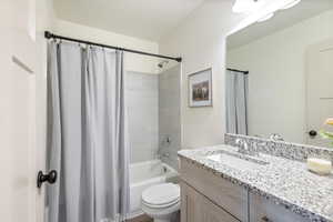 Full bathroom featuring vanity, toilet, and shower / bath combo with shower curtain