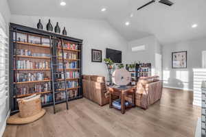 Sitting room featuring light hardwood / wood-style floors, lofted ceiling, and a wall unit AC