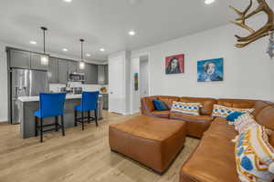 Living area featuring light wood finished floors, baseboards, and recessed lighting