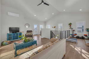 Living area featuring a ceiling fan, recessed lighting, a wall mounted air conditioner, and hardwood / wood-style floors