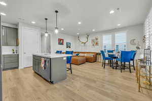 Kitchen with gray cabinets, visible vents, a sink, and light wood finished floors