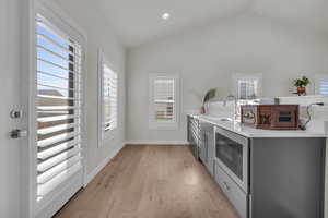 Laundry room with light wood-style floors, baseboards, a sink, and recessed lighting