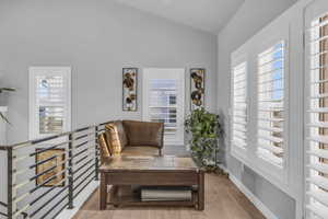 Sitting room featuring light hardwood / wood-style flooring and vaulted ceiling