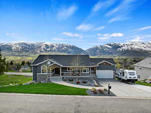 View of front of property featuring a mountain view, covered porch, and a garage