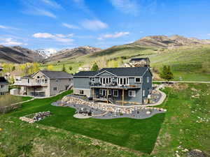 Rear view of house featuring a yard and a deck with mountain view