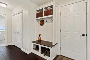 Mudroom with a textured ceiling and dark wood-type flooring