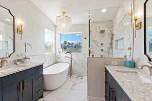 Bathroom with separate shower and tub, vanity, a chandelier, and tile walls