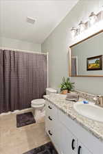 Bathroom with vanity, a textured ceiling, and toilet