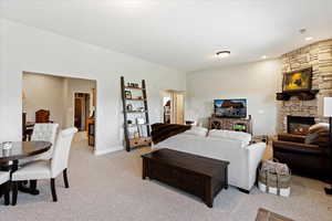 Living room featuring a stone fireplace and light colored carpet