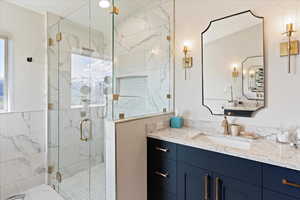 Bathroom featuring vanity and a shower with door