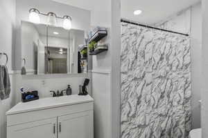 Bathroom with a shower with curtain and vanity