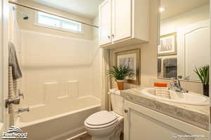 Full bathroom featuring shower / tub combo with curtain, vanity, and toilet