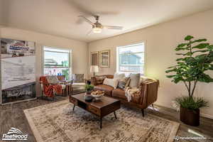 Living room featuring ceiling fan and dark wood-type flooring