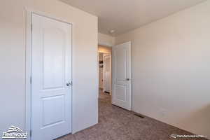 Unfurnished bedroom with light carpet