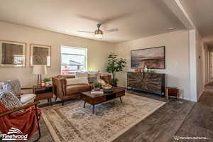 Living room featuring ceiling fan and dark hardwood / wood-style flooring