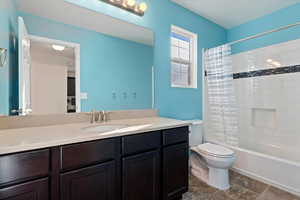 Full bathroom featuring vanity, shower / tub combo, and toilet