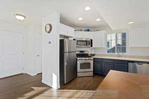 Kitchen with gray cabinetry, white cabinets, sink, dark hardwood / wood-style floors, and stainless steel appliances