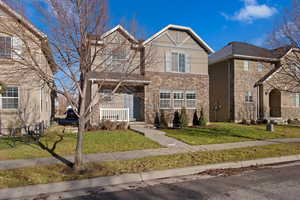 View of front of property featuring covered porch and a front lawn