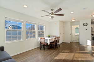 Dining area with ceiling fan and dark wood-type flooring