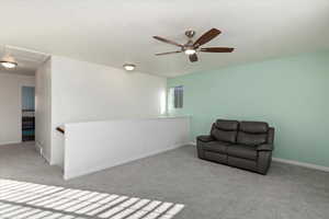 Sitting room featuring light colored carpet and ceiling fan