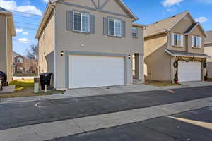 View of front of property featuring central AC and a garage