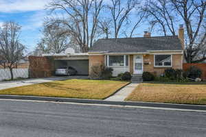 Single story home featuring a carport and a front lawn