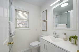 Upstairs bathroom with an enclosed shower, vanity, and toilet