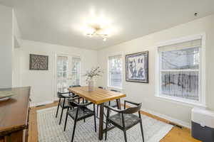 Dining area featuring french doors, light hardwood / wood-style floors, and a notable chandelier