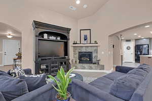 Living room featuring lofted ceiling, light wood-type flooring, and a fireplace