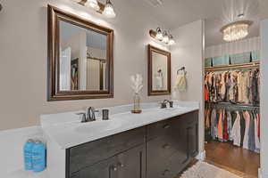 Bathroom with hardwood / wood-style flooring, vanity, and a notable chandelier