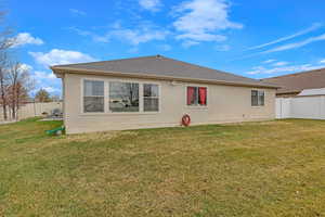 Rear view of property featuring a lawn