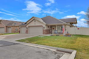 View of front of house featuring a front lawn, a porch, and a garage