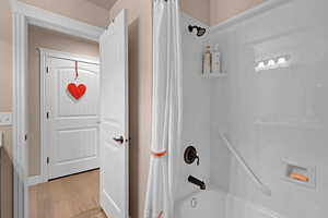 Bathroom featuring hardwood / wood-style flooring and shower / tub combo