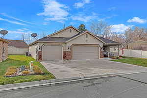 View of front of property with a garage, central air condition unit, and a front yard