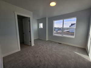 Unfurnished bedroom with a closet and carpet floors