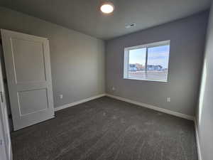 Empty room with dark colored carpet