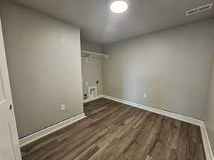 Laundry area with hookup for an electric dryer, washer hookup, and dark hardwood / wood-style floors