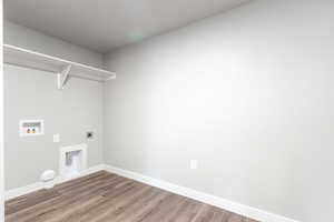 Laundry area with electric dryer hookup, hookup for a washing machine, dark wood-type flooring, and gas dryer hookup