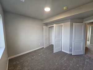 Unfurnished bedroom featuring dark colored carpet