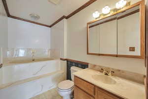 Bathroom with a bathing tub, crown molding, vanity, and toilet