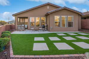 Backyard features an expansive patio and easy-care turf.