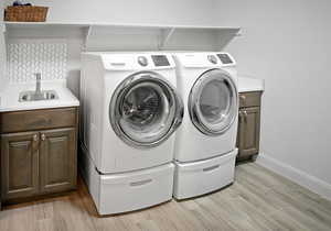 Laundry room has full lower cabinets, an upper shelf, as well as a sink with backsplash.