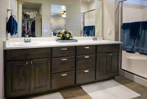 Bathroom featuring ceiling fan, dual vanity, tile flooring, and an enclosed shower.