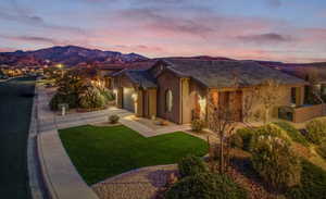 This beautiful home is the Topaz floor plan by Cole West Home in Brio. The exterior elevation is Spanish-style with a large curved central window, gated front porch, two car garage, and low maintenance turf.