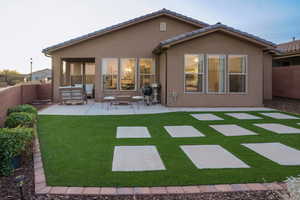 Back of property featuring outdoor lounge area, a patio, and turf.